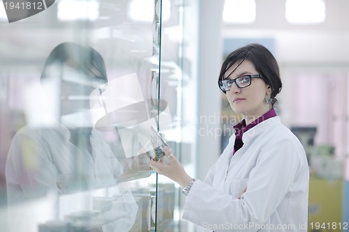 Image of pharmacist chemist woman standing in pharmacy drugstore