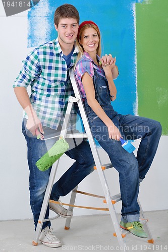 Image of happy couple paint wall at new home