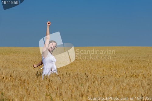 Image of young woman in wheat field at summer
