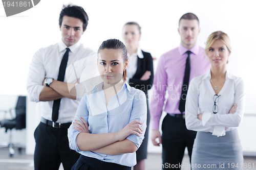 Image of business woman standing with her staff in background