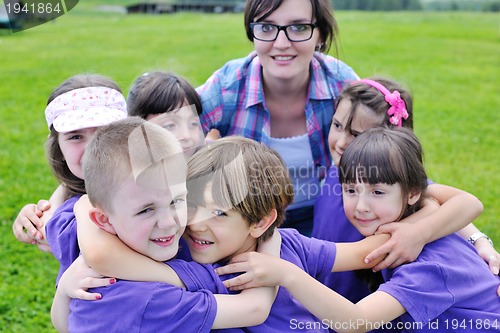 Image of happy kids group with teacher in nature