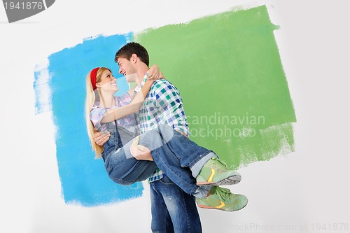 Image of happy couple paint wall at new home
