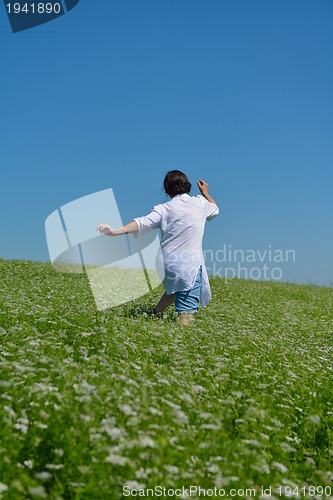 Image of Young happy woman in green field