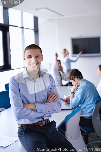 Image of business man  on a meeting in offce with colleagues in backgroun