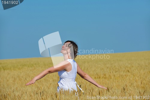 Image of young woman in wheat field at summer