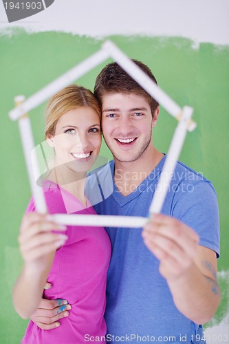 Image of happy couple paint wall at new home