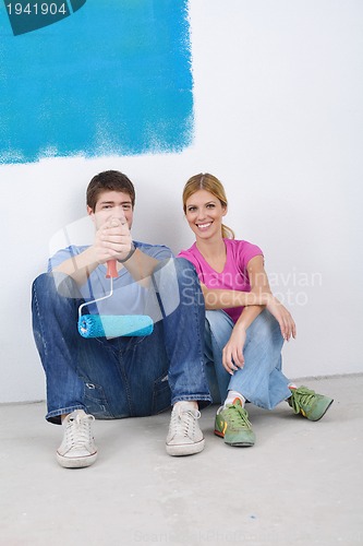 Image of happy young cople relaxing after painting in new home