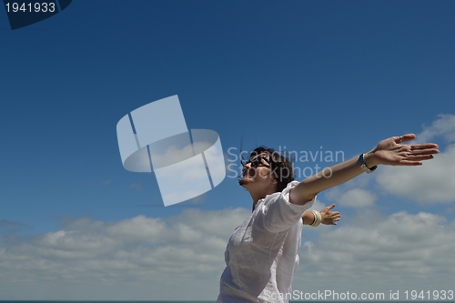 Image of young woman with spreading arms to sky