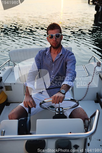 Image of portrait of happy young man on boat
