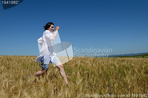 Image of young woman in wheat field at summer