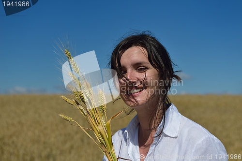 Image of young woman in wheat field at summer