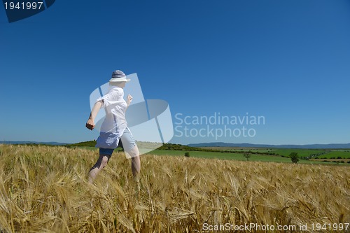 Image of young woman in wheat field at summer