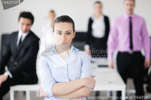 Image of business woman standing with her staff in background