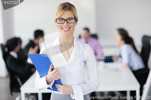 Image of business woman standing with her staff in background