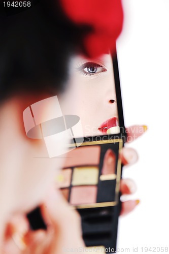 Image of beautiful young woman applying makeup