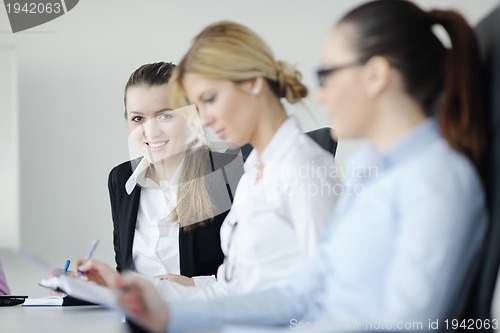 Image of business woman standing with her staff in background