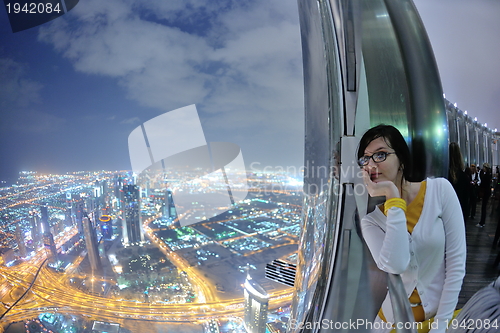 Image of beautiful woman portrait with big city at night in background