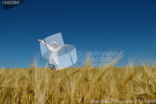 Image of young woman in wheat field at summer