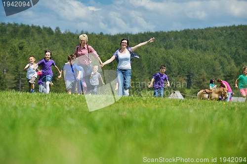 Image of happy kids group with teacher in nature