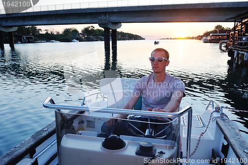 Image of portrait of happy young man on boat