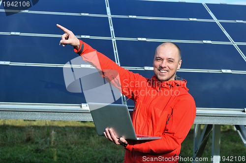 Image of engineer using laptop at solar panels plant field