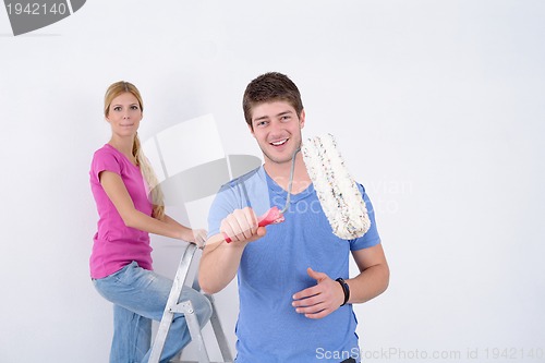 Image of happy couple paint wall at new home