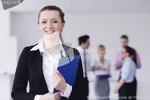 Image of business woman standing with her staff in background
