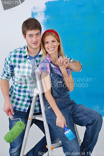 Image of happy couple paint wall at new home