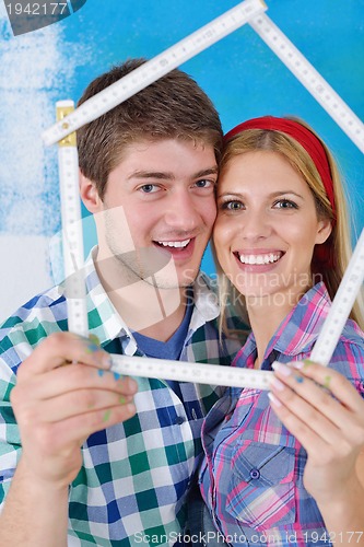 Image of happy couple paint wall at new home