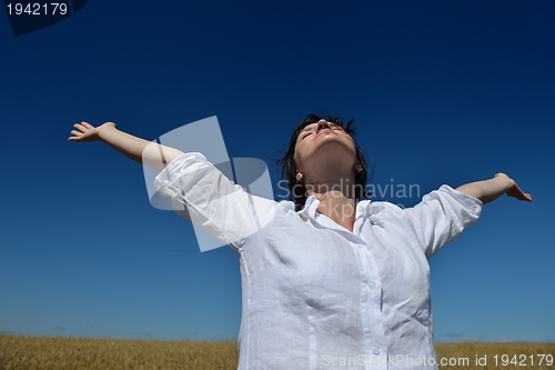 Image of young woman in wheat field at summer