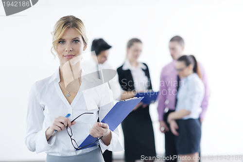 Image of business woman standing with her staff in background