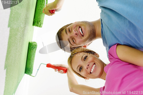 Image of happy couple paint wall at new home