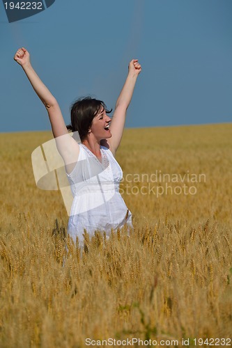 Image of young woman in wheat field at summer