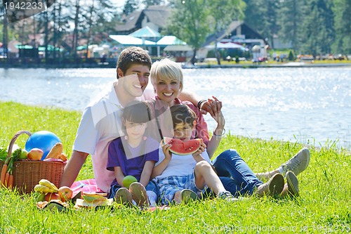 Image of Happy family playing together in a picnic outdoors