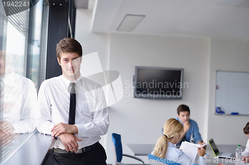 Image of business man  on a meeting in offce with colleagues in backgroun