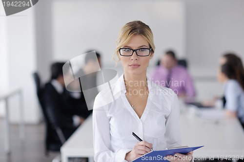 Image of business woman standing with her staff in background