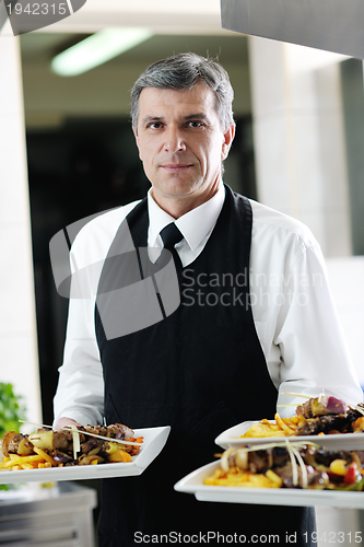 Image of male chef presenting food