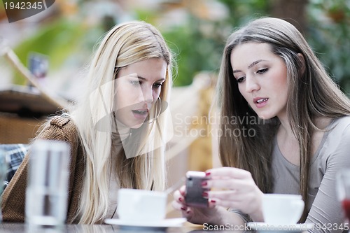 Image of cute smiling women drinking a coffee