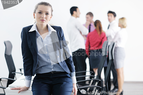 Image of business woman standing with her staff in background
