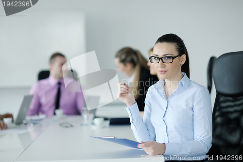 Image of business woman standing with her staff in background