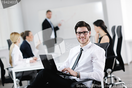 Image of handsome young business man with colleagues in background