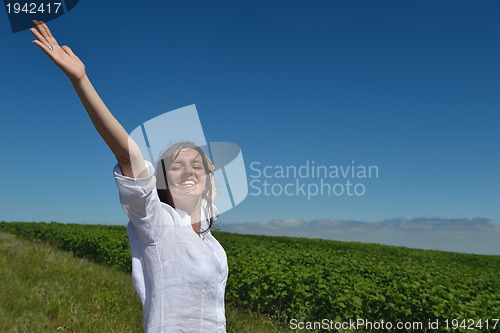 Image of Young happy woman in green field
