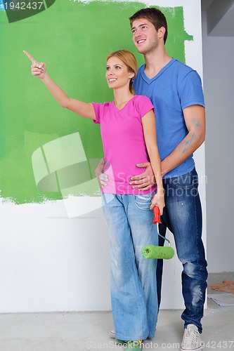 Image of happy couple paint wall at new home