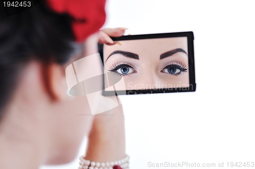 Image of beautiful young woman applying makeup