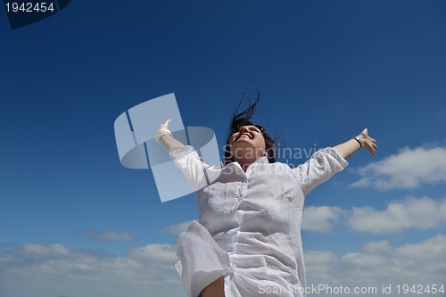 Image of young woman with spreading arms to sky