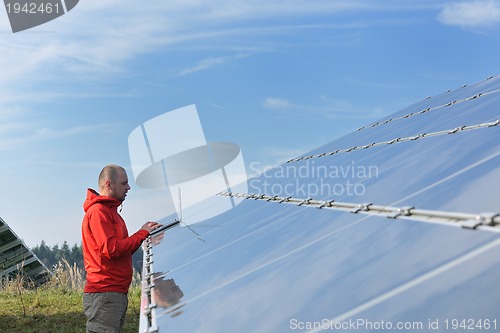 Image of engineer using laptop at solar panels plant field