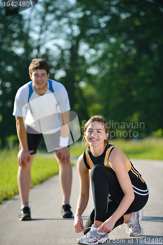 Image of Couple doing stretching exercise  after jogging
