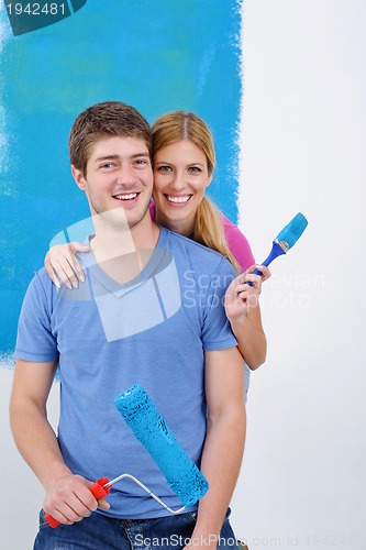 Image of happy couple paint wall at new home