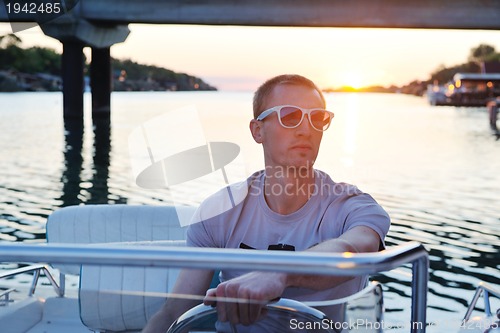 Image of portrait of happy young man on boat