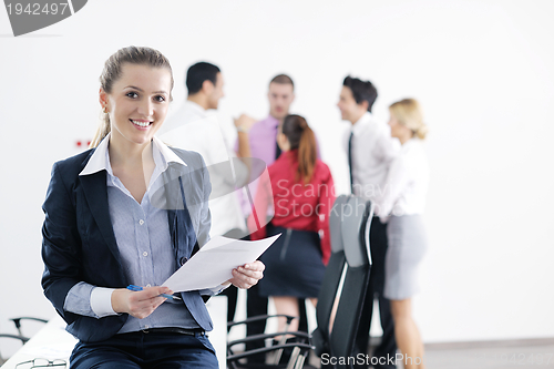 Image of business woman standing with her staff in background